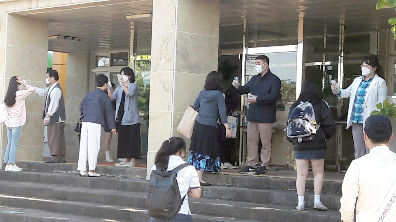학생들과 교직원들이 현관에서 발열검사를 받고 있다.(사진=양용주 기자)