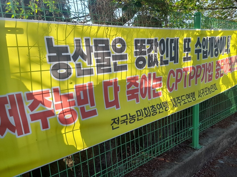 서귀포농민회가 서귀포향토오일장에 CPTPP 가입에 반대하는 내용으로 현수막을 게시했다.(사진=장태욱 기자)