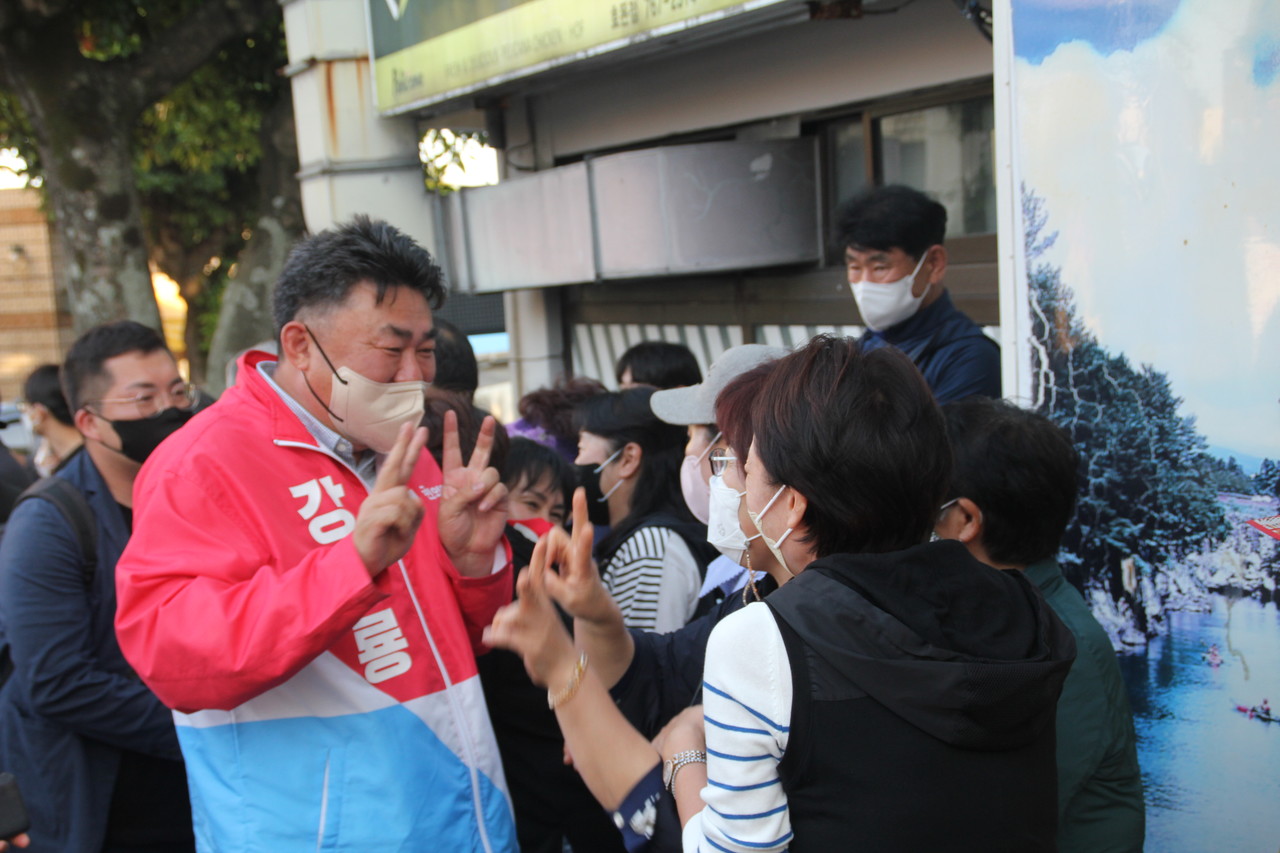 강충룡 후보가  주민들에게 브이를 그리며 지지를 호소하고 있다.