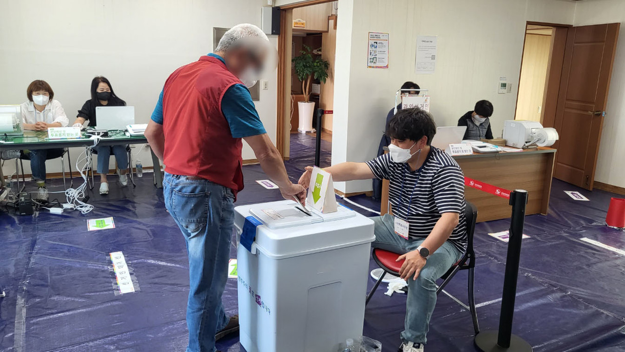 정방동 사전투표소에서 한 유권자가 투표용지를 투표함에 넣고 있다.(사진=강문혁 기자)