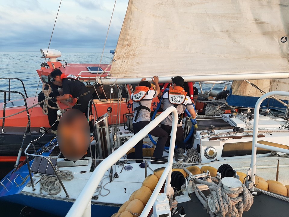 해경이 배수작업을 하면서 구조정에 요트를 묶고 강정항으로 예인했다.(사진=서귀포해경 제공)