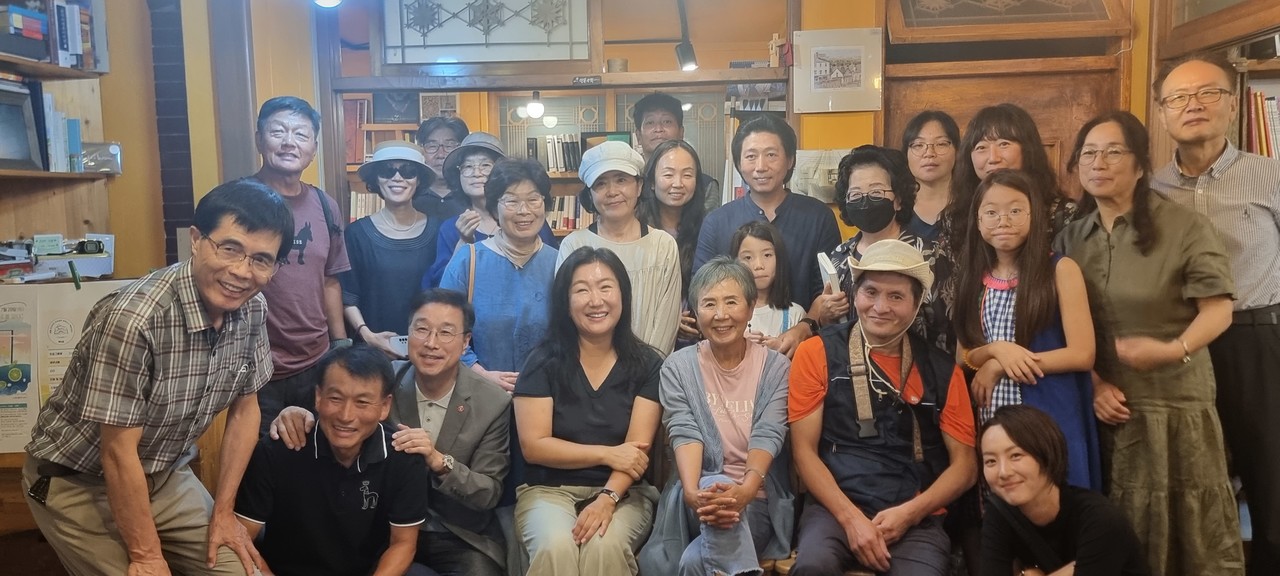 북타임에서 서명숙 작가의 북토크에 모인 사람들이 함께 기념촬영을 하고 있다.