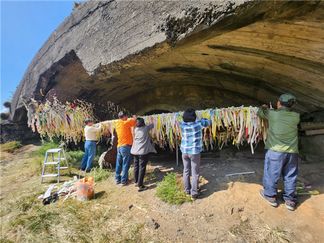 그림 비행기 조형작품의 원형을 드러내기 위해 리본 제거작업을 하고있는 대정현문학회 회원들