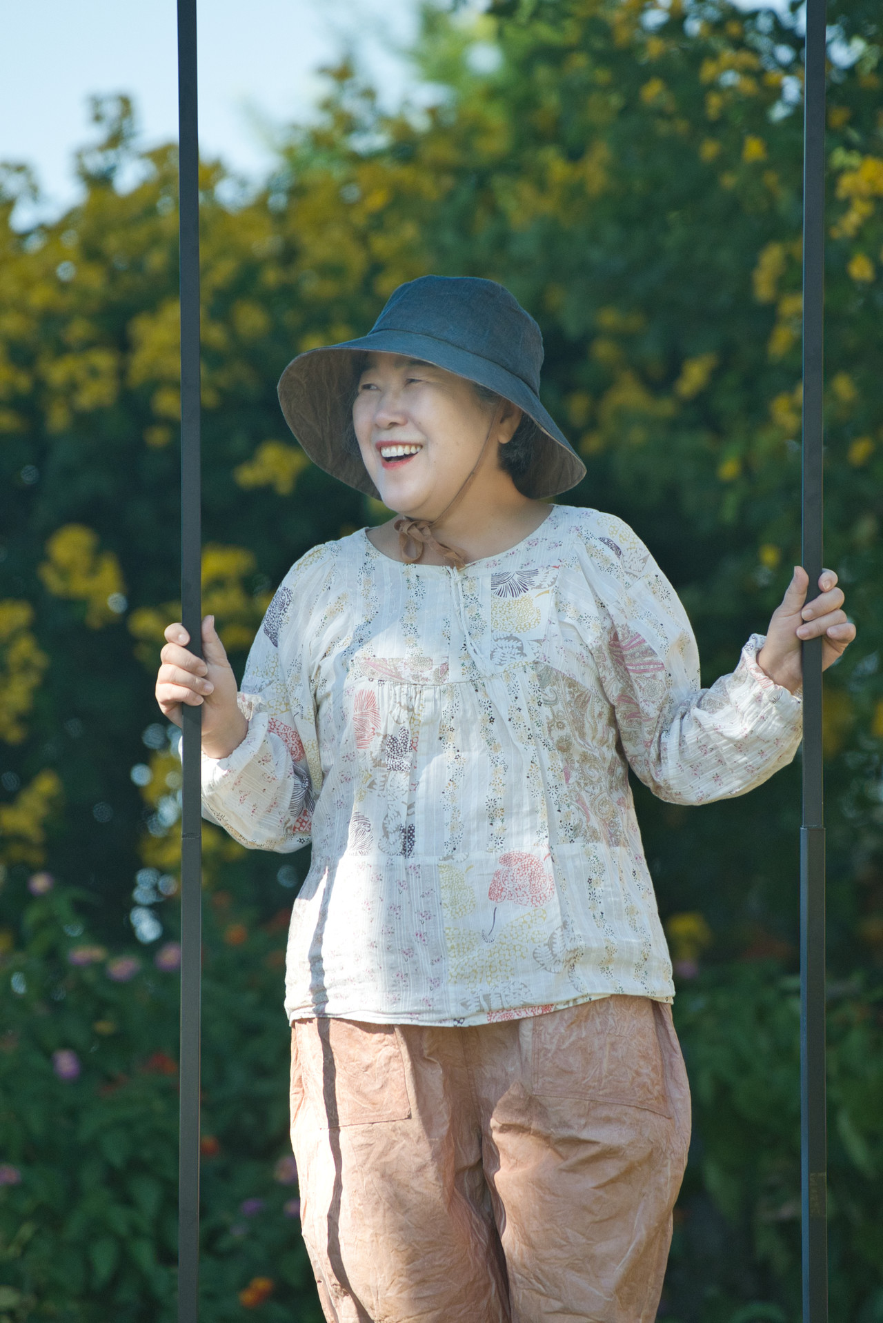 수업에 참여한 한경희 수강생이 제작한 옷을 입고 감귤밭을 거닐며 활짝 웃고 있다.