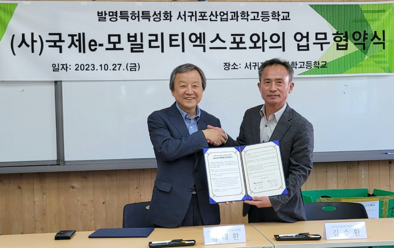 27일 서귀포산과고에서 열린 국제e-모빌리티엑스포와 서귀포산과고 간 업무협약식에서 김대환 IEVE 이사장(왼쪽)과 김수환 서귀포산과고 교장이 협약서에 서명한 후 기념촬영을 하고 있다.