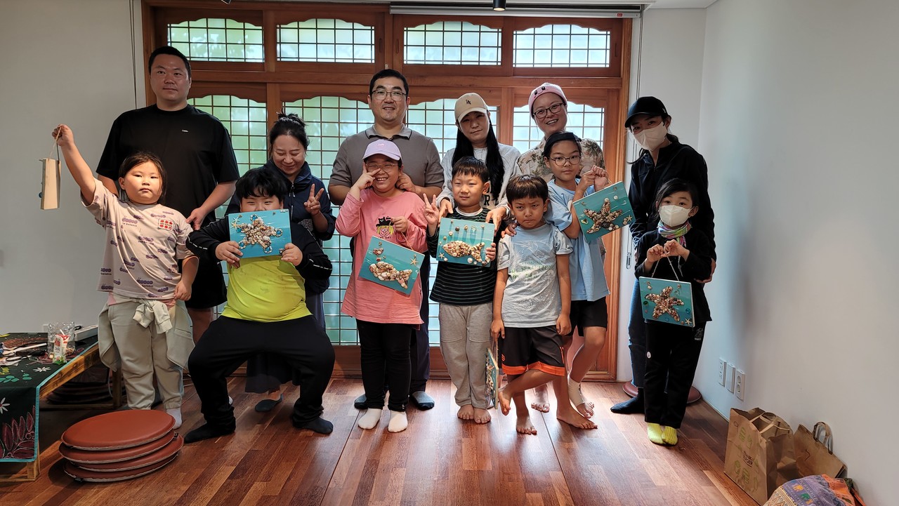 아이들과 학부모들이 수집한 조개껍데기로 가족액자를 만들어 기념촬영을 하고 있다. 