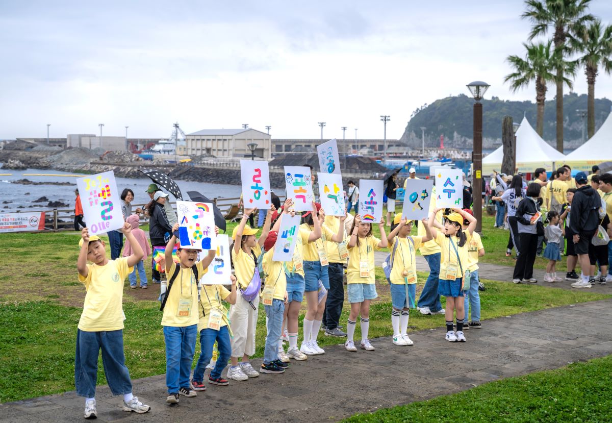 어린이기획단이 자구리 공원에서 도착하는 참가자를 응원하고 있다.