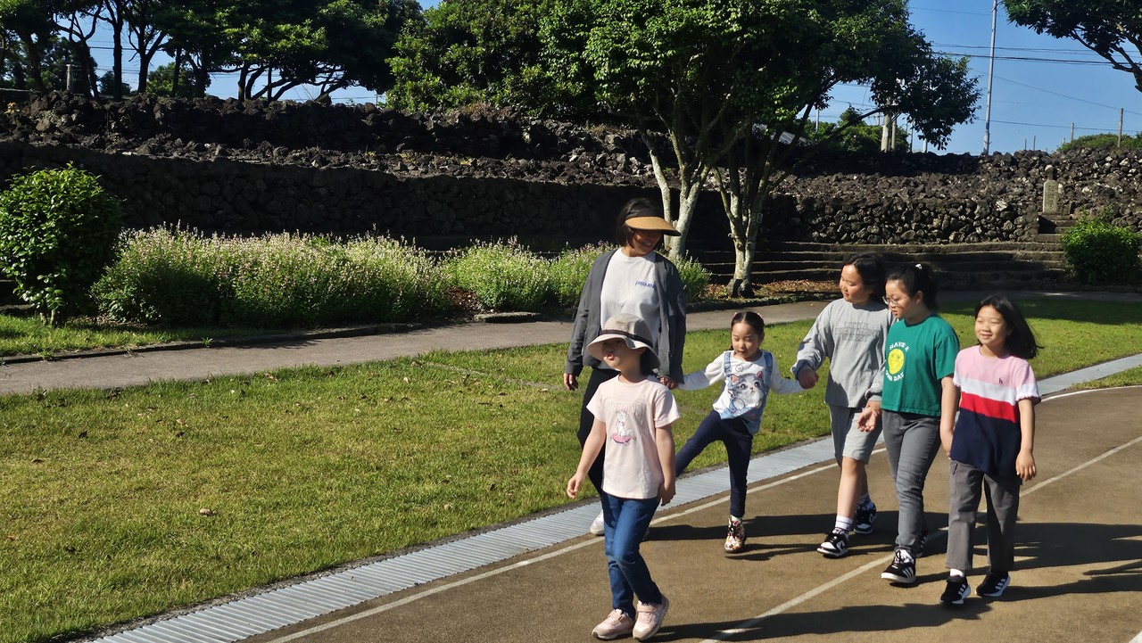 지난달 27일 수산초등학교 운동장에서 '수산교육가족'이 혼디걷기를 하고 있다.