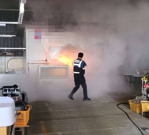 지난 26일 오전 10시15분쯤 ‘중문오일시장 내에서 불이 난 것 같다’는 신고를 받고 현장으로 출동한 경찰이  소화기를 이용해 초기진화를 하고 있다.