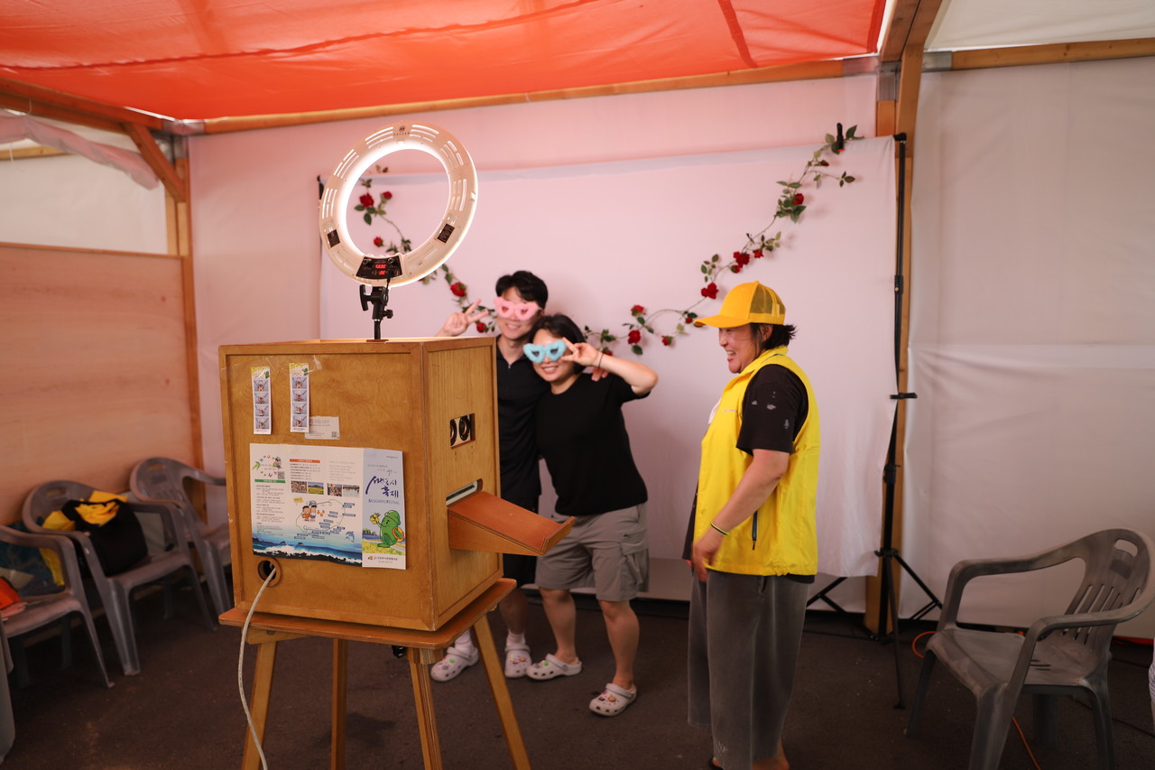 지난 8일 충남 보령에서 열린 제28회 보령머드축제에서 관광객 이진형‧강지영씨(32·전주)가 서귀포시관광협의회의 '서귀포옵서예' 홍보 부스에서 인생네컷 즉석사진을 찍으며 포즈를 취하고 있다.  고권봉 기자
