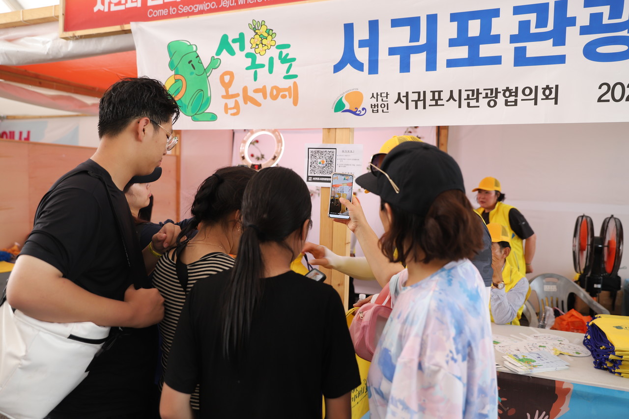 지난 8일 충남 보령에서 열린 제28회 보령머드축제에서 가족과 연인, 외국인 관광객들이 서귀포시관광협의회의 '서귀포옵서예' 홍보 부스에서 다양한 정보를 얻고 있다.  고권봉 기자